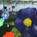 bright purple flower surrounded by line of other flower yard decorations