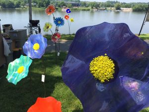 bright purple flower surrounded by line of other flower yard decorations