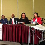 Older white man (Dennis Owens) addresses five candidates dressed in professional attire. Harrisburg Young Professional sign is in front of their panel.